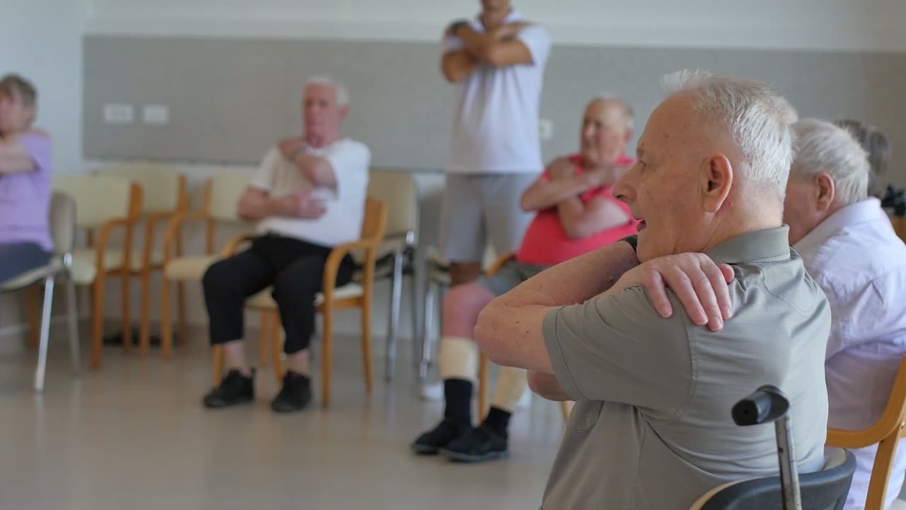 Starejši med vajami z žogami in palicami na stolih
